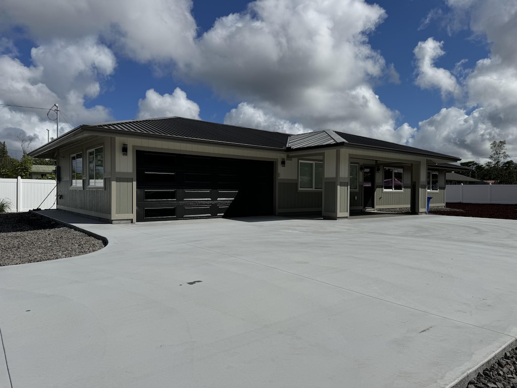 16-2102 Jewel Dr, Pahoa, HI 96778 - view of front of home featuring a garage, concrete driveway, a metal roof, and a standing seam roof