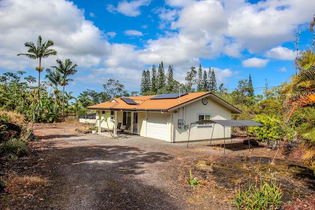 16-380 Melekule St, Kurtistown, HI 96760 - view of front of house featuring a garage, solar panels, and dirt driveway