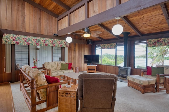 1559 Kilikina St, Hilo, HI 96720 - living room with a wood stove, wood ceiling, wooden walls, a ceiling fan, and light colored carpet