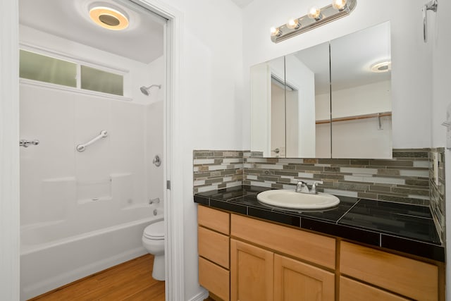 6450 Olohena Rd, Kapaa, HI 96746 - bathroom with toilet, vanity, wood finished floors, tasteful backsplash, and shower / washtub combination