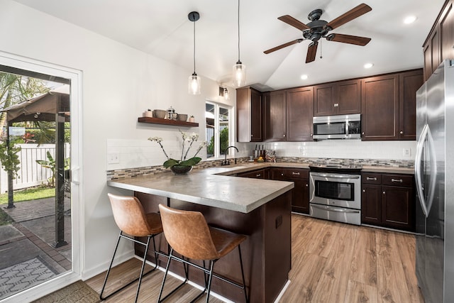 73-1060 Kuuleialoha Cir, Kailua-Kona, HI 96740 - kitchen featuring appliances with stainless steel finishes, a sink, a peninsula, dark brown cabinetry, and healthy amount of natural light