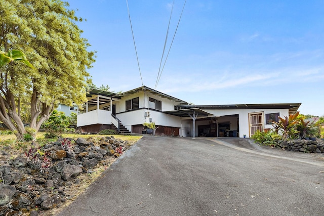 81-964 S Kahapili Loop, Kealakekua, HI 96750 - mid-century home featuring asphalt driveway, stucco siding, stairs, and an attached garage