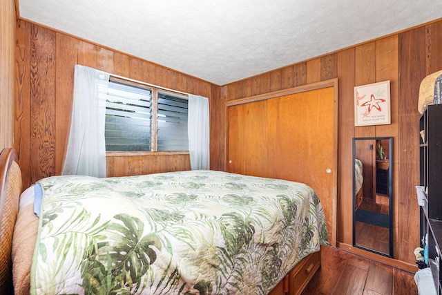 81-964 S Kahapili Loop, Kealakekua, HI 96750 - bedroom with wooden walls, hardwood / wood-style floors, a closet, and a textured ceiling