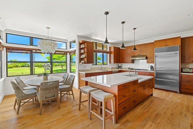 2739 Uluwehi St, Koloa, HI 96756 - kitchen with stainless steel built in fridge, under cabinet range hood, light countertops, a sink, and light wood-style floors