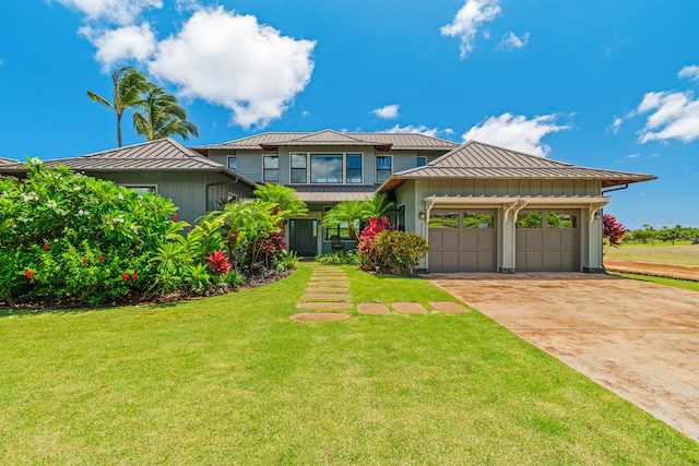 2739 Uluwehi St, Koloa, HI 96756 - view of front facade with board and batten siding, a standing seam roof, an attached garage, driveway, and metal roof