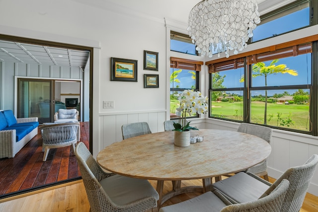 2739 Uluwehi St, Koloa, HI 96756 - dining area featuring wood-type flooring, a wainscoted wall, a decorative wall, and a chandelier
