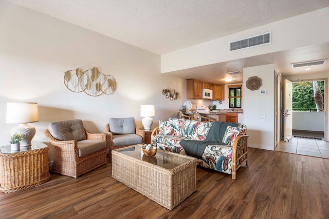 75-6040 Alii Dr Unit 504, Kailua-Kona, HI 96740 - living area featuring wood finished floors, baseboards, and a textured ceiling