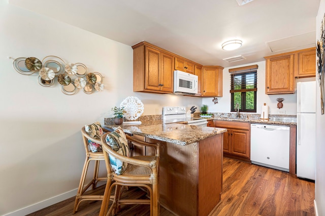 75-6040 Alii Dr Unit 504, Kailua-Kona, HI 96740 - kitchen featuring white appliances, a sink, a peninsula, dark wood finished floors, and light stone counters