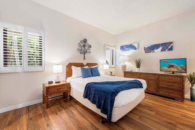 75-6040 Alii Dr Unit 504, Kailua-Kona, HI 96740 - bedroom with multiple windows, wood finished floors, and baseboards