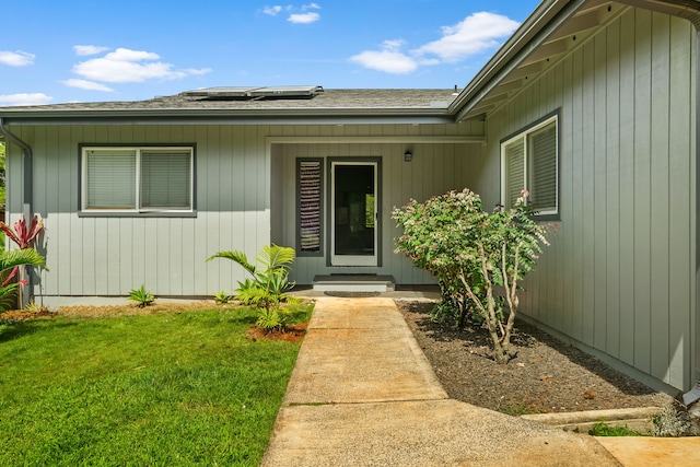 3968 Pai St, Kalaheo, HI 96741 - doorway to property featuring solar panels, a lawn, and roof with shingles