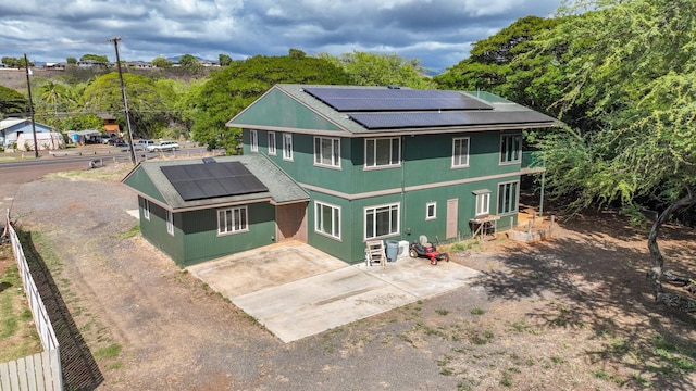1-3580 Kaumualii Hwy, Hanapepe, HI 96716 - back of house featuring roof mounted solar panels, roof with shingles, concrete driveway, and a patio