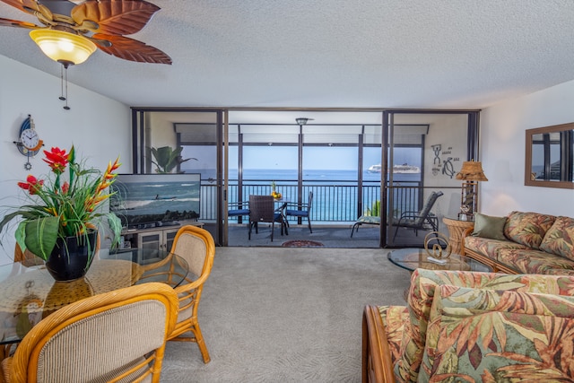 75-5782 Kuakini Hwy Unit 504, Kailua-Kona, HI 96740 - living area with carpet floors, a textured ceiling, a ceiling fan, and floor to ceiling windows