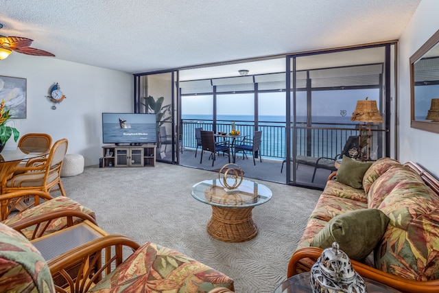 75-5782 Kuakini Hwy Unit 504, Kailua-Kona, HI 96740 - carpeted living room featuring a ceiling fan, a textured ceiling, and expansive windows
