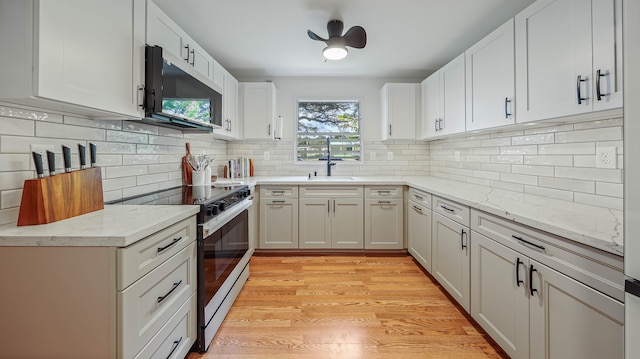 3189 Hikina Rd, Koloa, HI 96756 - kitchen featuring stainless steel microwave, stove, a sink, light stone countertops, and tasteful backsplash