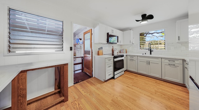 3189 Hikina Rd, Koloa, HI 96756 - kitchen featuring electric range, a sink, light wood-style floors, and backsplash