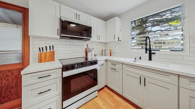 3189 Hikina Rd, Koloa, HI 96756 - kitchen with electric stove, white microwave, a sink, light stone countertops, and backsplash