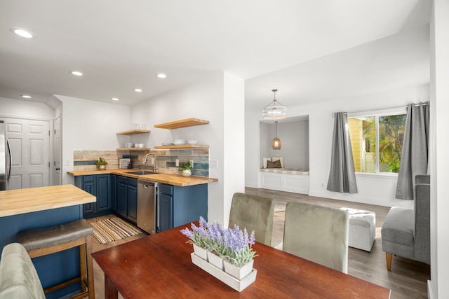 1964 Haleukana St, Lihue, HI 96766 - kitchen featuring butcher block countertops, blue cabinetry, dishwasher, backsplash, and a sink