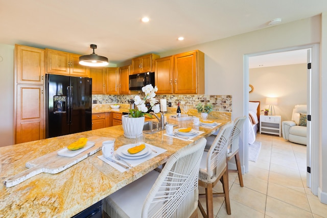 68-3840 Lua Kula St Unit H100, Waikoloa, HI 96738 - kitchen featuring black appliances, tasteful backsplash, light tile patterned flooring, a breakfast bar area, and a sink