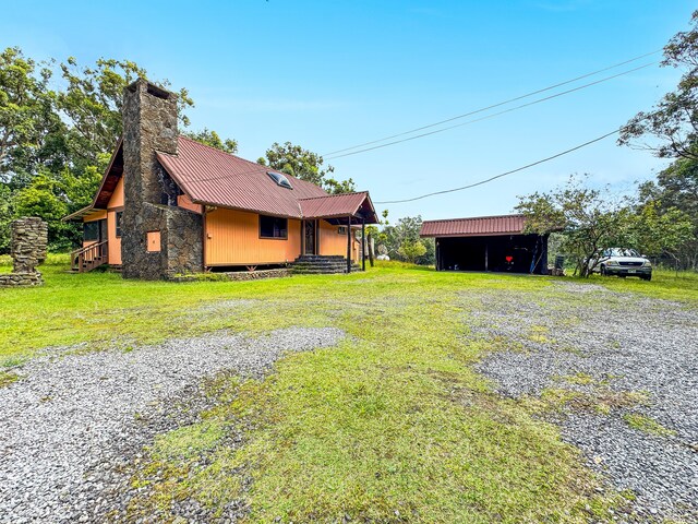 94-2664 Lorenzo Rd, Naalehu, HI 96772 - view of property exterior with metal roof, a chimney, a lawn, stone siding, and a pole building