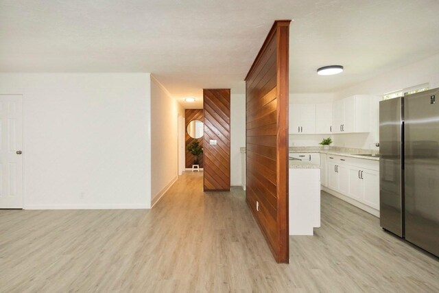 14-3479 Nanawale Blvd, Pahoa, HI 96778 - kitchen with freestanding refrigerator, light wood-style flooring, a sink, wood walls, and white cabinetry
