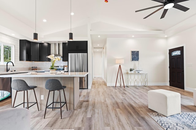 16-2072 Bamboo Dr, Pahoa, HI 96778 - kitchen featuring freestanding refrigerator, dark cabinetry, lofted ceiling, light countertops, and wall chimney range hood
