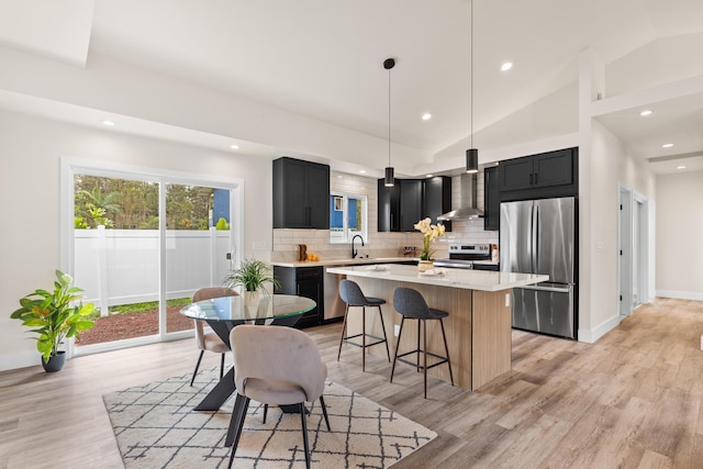16-2072 Bamboo Dr, Pahoa, HI 96778 - kitchen with appliances with stainless steel finishes, wall chimney range hood, dark cabinetry, vaulted ceiling, and light countertops