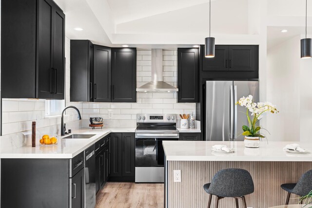16-2072 Bamboo Dr, Pahoa, HI 96778 - kitchen with stainless steel appliances, wall chimney range hood, a sink, dark cabinetry, and a kitchen bar