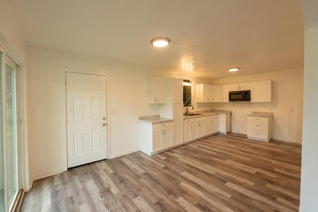 15-2746 Lai St, Pahoa, HI 96778 - kitchen featuring black microwave, wood finished floors, white cabinets, a sink, and baseboards