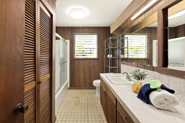 27-296 Kaieie Rd, Papaikou, HI 96781 - bathroom with wood walls, toilet, vanity, a closet, and enclosed tub / shower combo