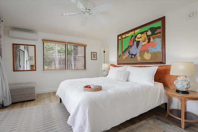 78-261 Manukai St Unit 3403, Kailua-Kona, HI 96740 - bedroom featuring a wall mounted air conditioner, wood finished floors, baseboards, and ceiling fan