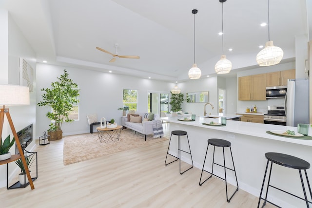 16-2050 Coconut Dr, Pahoa, HI 96778 - kitchen featuring stainless steel appliances, light wood-type flooring, a kitchen bar, open floor plan, and light countertops