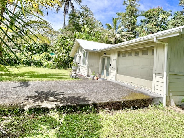 15-240 N Puni Makai Loop, Pahoa, HI 96778 - view of property exterior with an attached garage, a lawn, and driveway