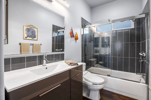 73-4100 Kulanui Pl, Kailua-Kona, HI 96740 - bathroom featuring toilet, combined bath / shower with glass door, vanity, and wood finished floors