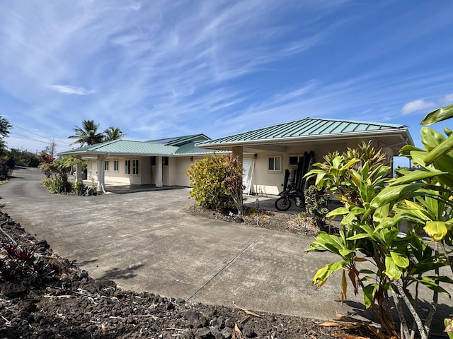 73-1125 Hamanamana St, Kailua-Kona, HI 96740 - back of house featuring a standing seam roof, metal roof, stucco siding, a porch, and driveway