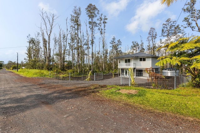 16-2097 Azure Dr, Pahoa, HI 96778 - view of front of home with dirt driveway, a balcony, and metal roof