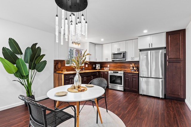 16-2097 Azure Dr, Pahoa, HI 96778 - kitchen featuring appliances with stainless steel finishes, tasteful backsplash, dark wood-style floors, white cabinets, and baseboards