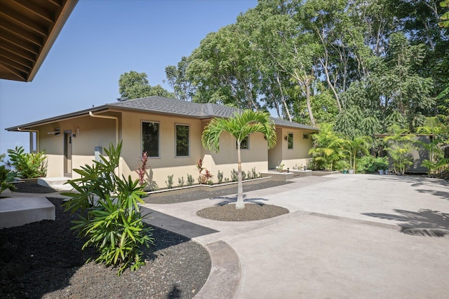 75-2620 Keopu Lani Rd, Holualoa, HI 96725 - view of front of house with stucco siding, roof with shingles, driveway, and a patio
