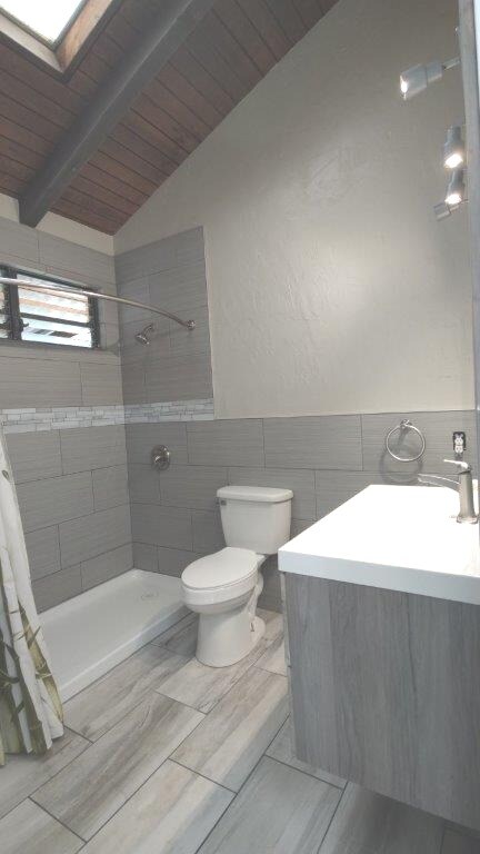 73-4692 Old Mamalahoa Hwy, Kailua-Kona, HI 96740 - full bathroom featuring wood ceiling, toilet, a tile shower, tile walls, and vanity