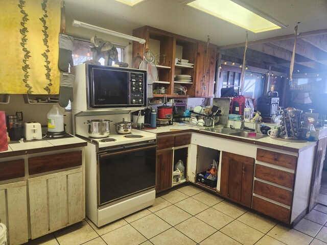 88-1501 Ala Malino Rd, Captain Cook, HI 96704 - kitchen with black microwave, tile counters, light tile patterned floors, electric range, and open shelves