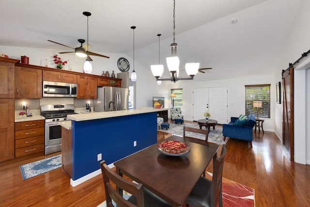 12-160 Moanauli Loop, Pahoa, HI 96778 - dining area with a barn door, ceiling fan, dark wood-style floors, plenty of natural light, and high vaulted ceiling