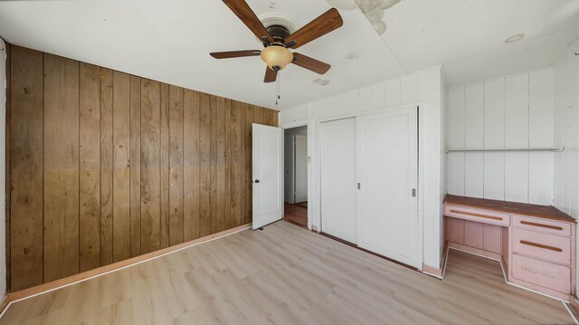 267 Hookipa Rd, Kapaa, HI 96746 - unfurnished bedroom with light wood-type flooring, wooden walls, a closet, and ceiling fan