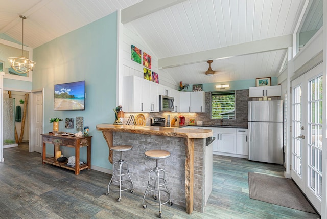 5-7330 Kuhio Hwy Unit B, Hanalei, HI 96714 - kitchen with appliances with stainless steel finishes, dark wood-style floors, backsplash, beam ceiling, and a kitchen breakfast bar