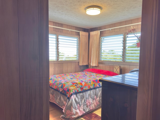 82-1091 Kinue Rd, Captain Cook, HI 96704 - bedroom featuring wood walls, a textured ceiling, and wood finished floors
