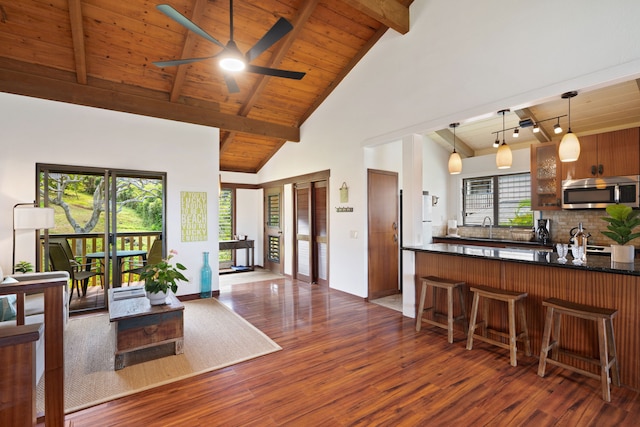 1870 Hoone Rd Unit 600, Koloa, HI 96756 - kitchen with stainless steel microwave, wood finished floors, ceiling fan, a kitchen breakfast bar, and wooden ceiling with exposed beams