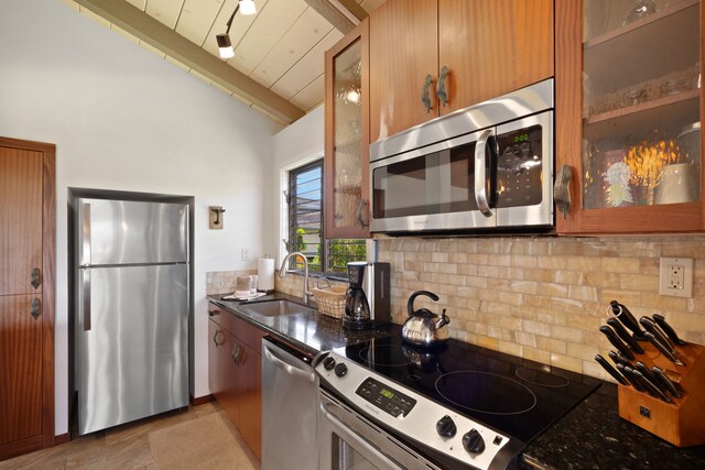 1870 Hoone Rd Unit 600, Koloa, HI 96756 - kitchen featuring appliances with stainless steel finishes, a sink, tasteful backsplash, glass insert cabinets, and brown cabinets