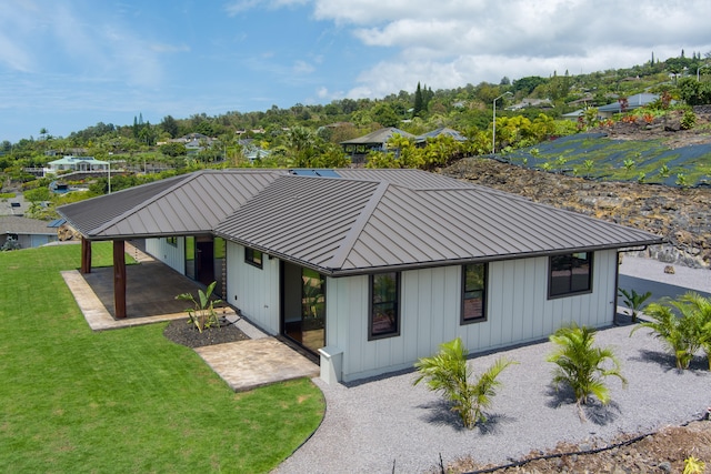73-4493 Aloha Pl, Kailua-Kona, HI 96740 - view of front facade with a patio, a front lawn, a metal roof, a standing seam roof, and board and batten siding