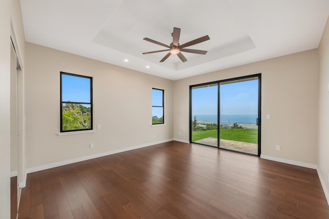 73-4493 Aloha Pl, Kailua-Kona, HI 96740 - empty room featuring a tray ceiling, dark wood finished floors, ceiling fan, recessed lighting, and a water view