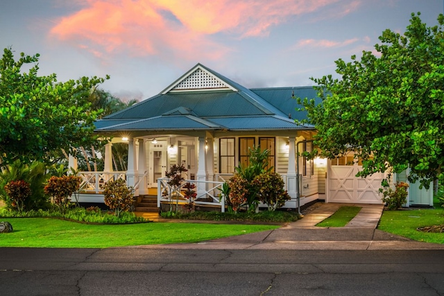 2640 Uluwehi St, Koloa, HI 96756 - view of front facade featuring a porch, concrete driveway, a front yard, and metal roof