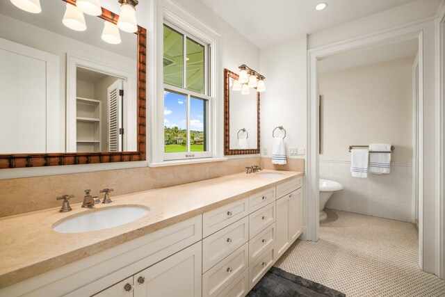 2640 Uluwehi St, Koloa, HI 96756 - full bathroom with double vanity, tile walls, wainscoting, a soaking tub, and recessed lighting