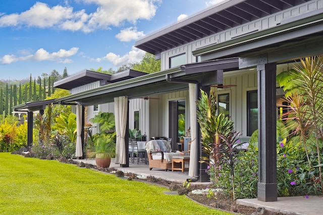74-941 Kuni St, Kailua-Kona, HI 96740 - rear view of house with board and batten siding, a ceiling fan, a lawn, and outdoor lounge area